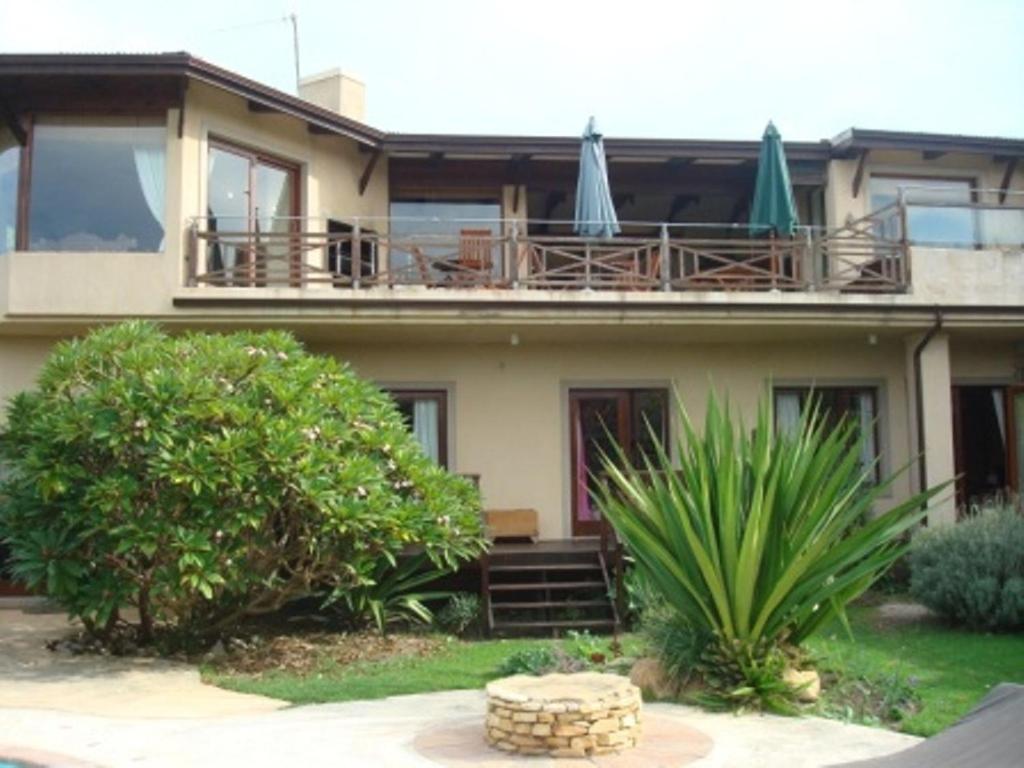 a house with two umbrellas on top of it at A Whale of a View Bed & Breakfast in Plettenberg Bay