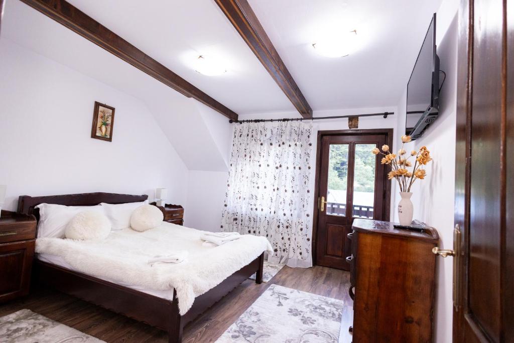 a bedroom with a bed and a window and a door at Cabana Walter Busteni cu BBQ & Terasa Privata in Buşteni