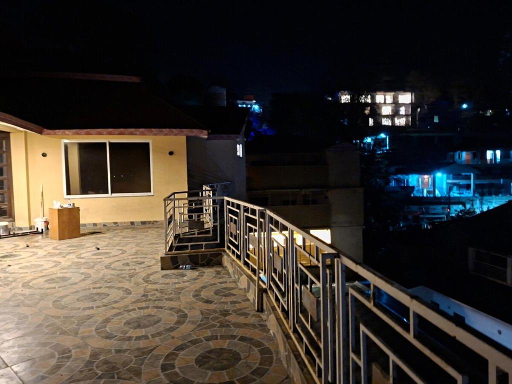 a balcony of a house at night with a fence at 4 Bedroom Penthouse - ELEV8 in Murree