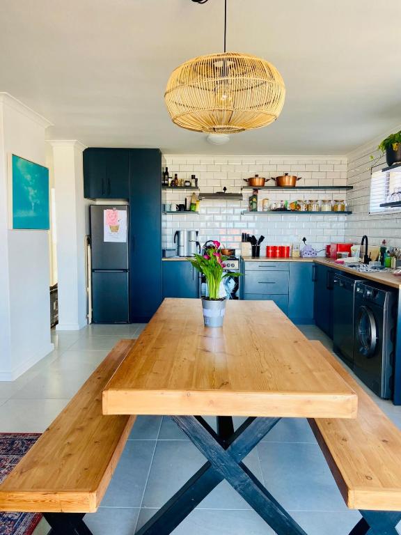 a wooden table in a kitchen with blue cabinets at Stylish beachside Gem in Fish Hoek in Fish Hoek