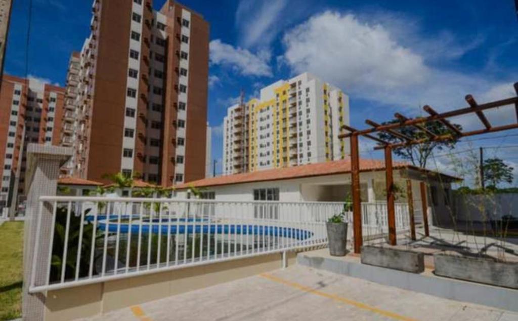 a swimming pool in front of some tall buildings at Aconchegante Cobertura duplex in Belém