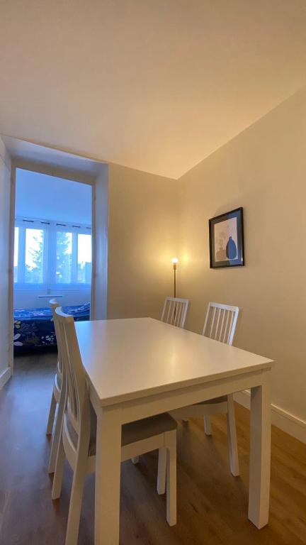 a dining room with a white table and chairs at Le Béarnois - 3 Chambres - Myra Conciergerie in Pau