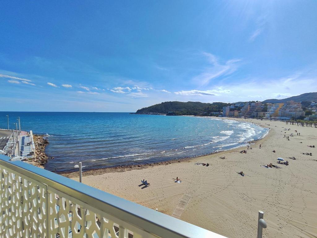 a beach with people on the sand and the ocean at El mirador de La Concha in Oropesa del Mar
