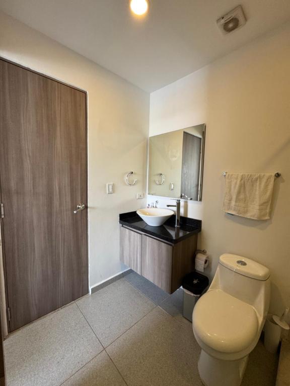 ein Badezimmer mit einer weißen Toilette und einem Waschbecken in der Unterkunft Apartamento con hermosa vista y piscina en Santa Marta in Gaira