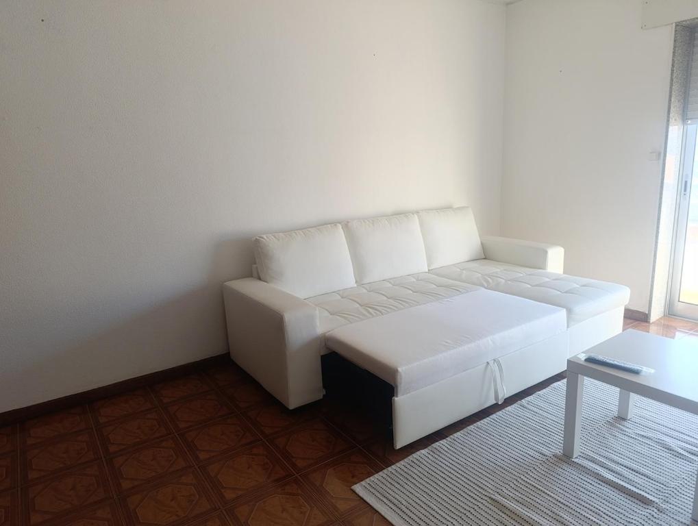 a white couch in a room with a table at Apartamento T2 Vista mar in Vila do Conde