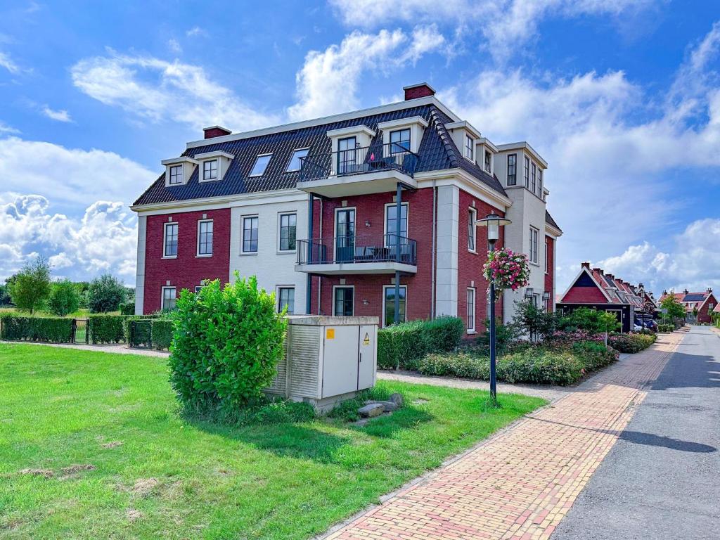 a large red and white house on the side of a street at Top luxe 27G in Colijnsplaat
