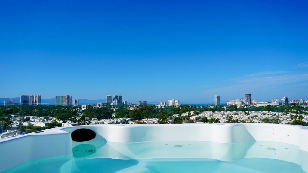 a bath tub with a view of the city at Modern, with Ocean and Mountain View in Puerto Vallarta
