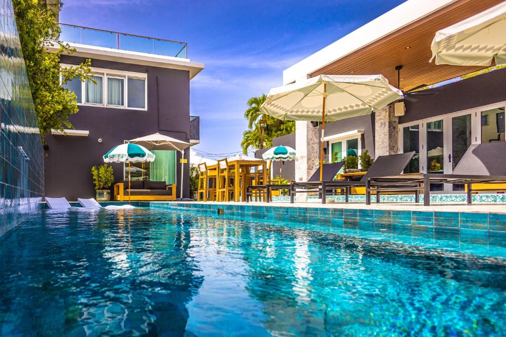 una piscina davanti a una casa di El Gatsby - KingRoom Pool - Resort Vibe Near Beach a San Juan