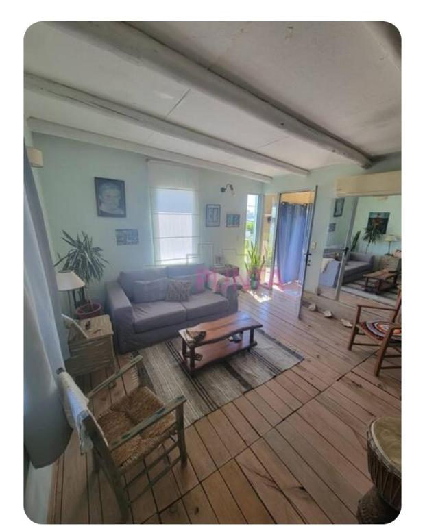 una sala de estar con un sofá y una mesa en El Carolino, a residence meters from the sea, en Balneario Buenos Aires