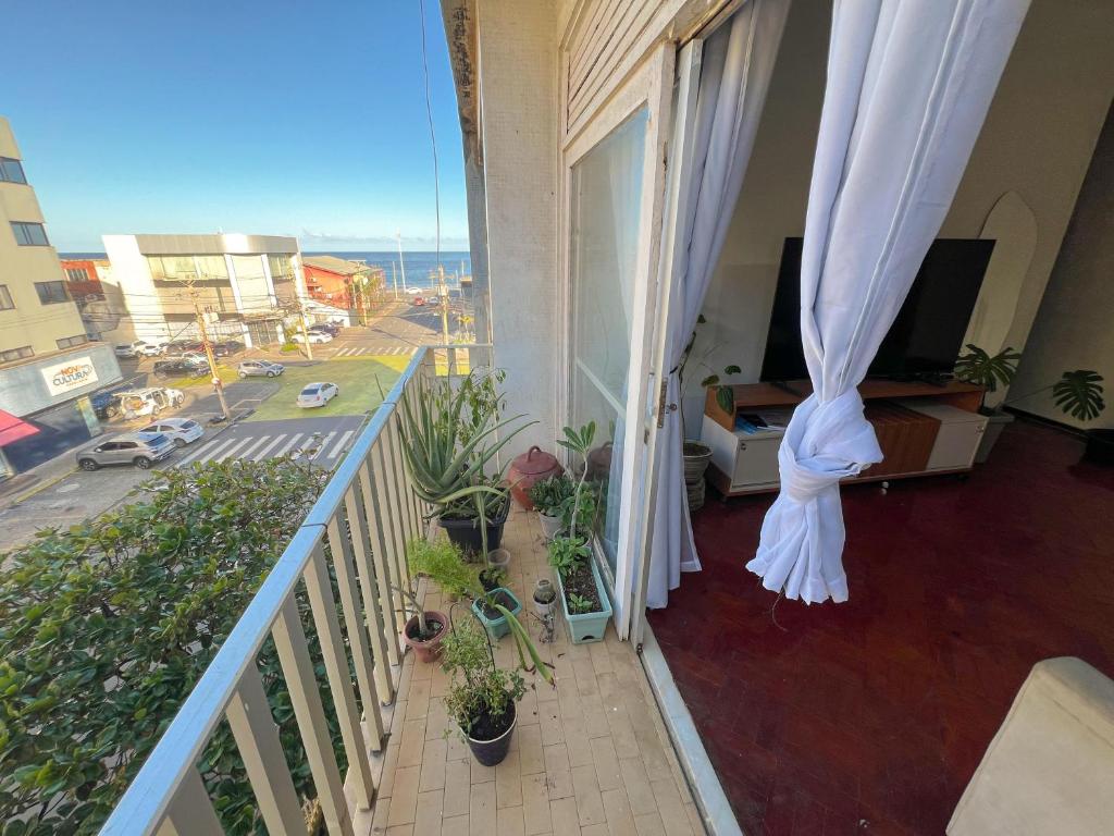 a balcony with potted plants and a balcony with a view of a city at Quarto na Pituba in Salvador