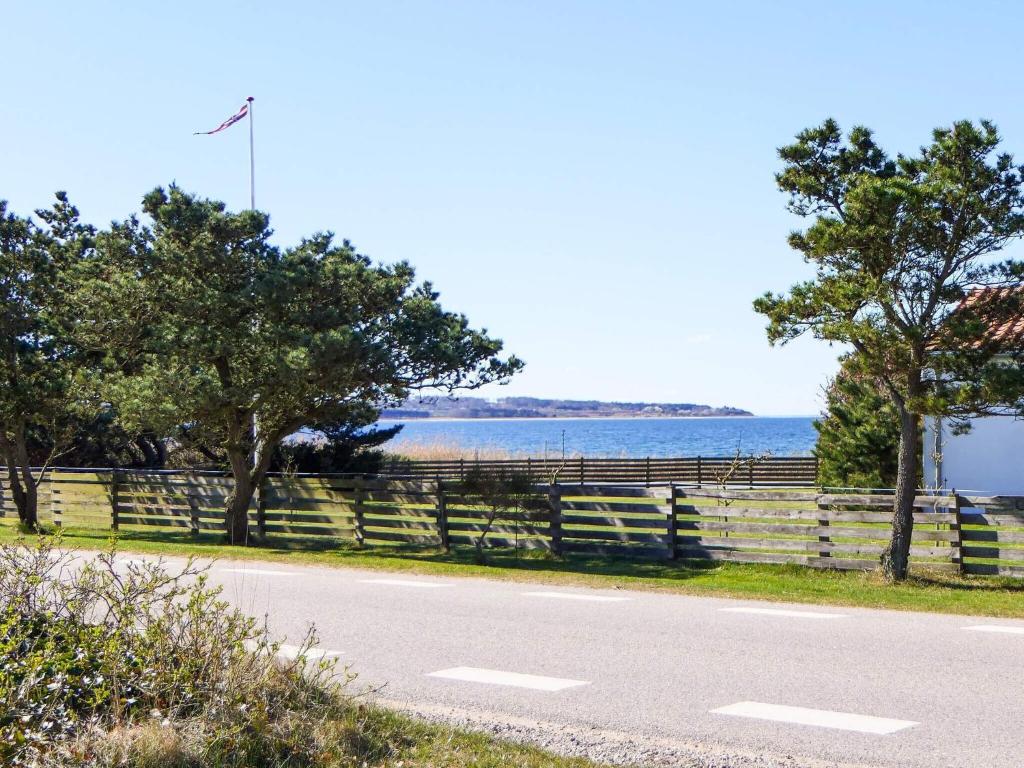 a road with a fence next to the water at 4 person holiday home in Knebel in Knebel
