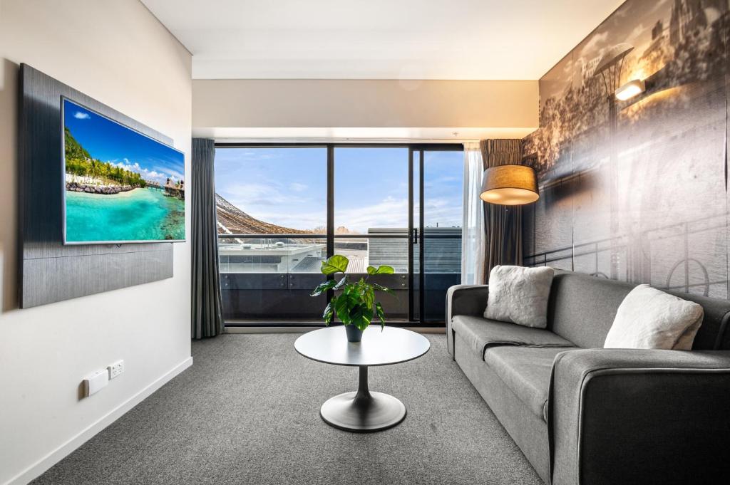 a living room with a couch and a tv at Spacious Apartment in Heart of Southbank in Melbourne