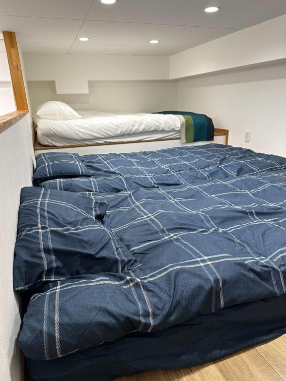 Ένα ή περισσότερα κρεβάτια σε δωμάτιο στο 101 Melon Home 難波日本橋 徒歩10分 黒門市場 徒歩5分 心斎橋 1駅 広いお部屋