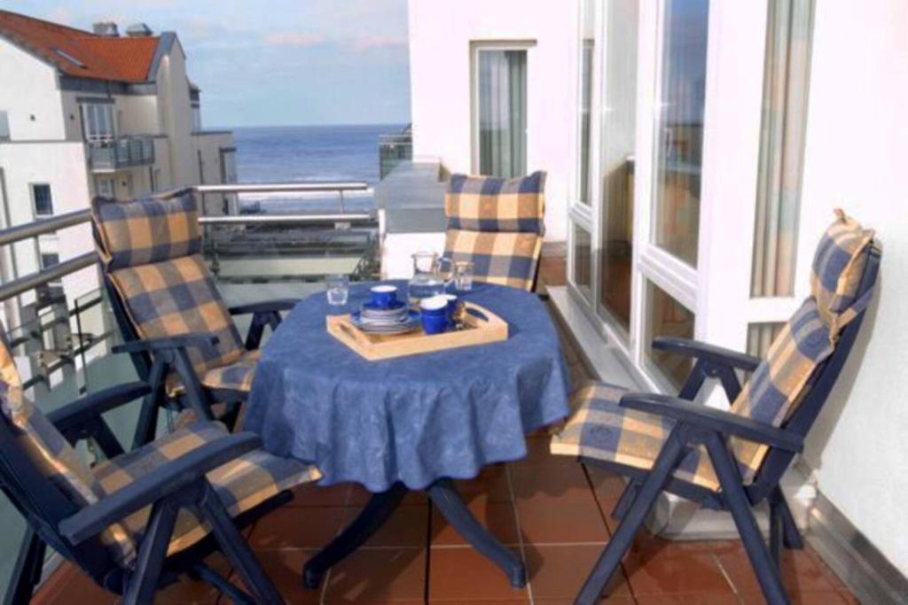 a table and chairs on a balcony with the ocean at Kaiserhof 302 in Wangerooge