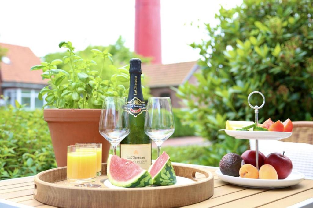 a table with a bottle of wine and a plate of fruit at Lighthousestudio & Spa- Exclusive Entspannt Besonders in Wangerooge