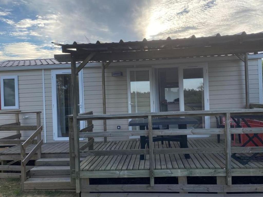 a house with a large wooden deck with a porch at Mobil-home 33m² avec terrasse au Boulou - API-1-52-398 in Le Boulou