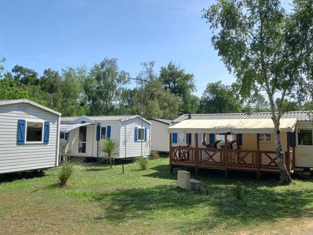a row of mobile homes parked in a yard at Mobil home 8 pers avec terrasse à Saint-Sornin - API-1-52-461 in Saint-Sornin
