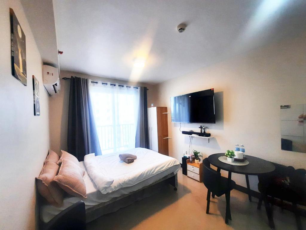 a room with a bed and a table and a window at JJL Suites for DAILY RENTAL in Suba