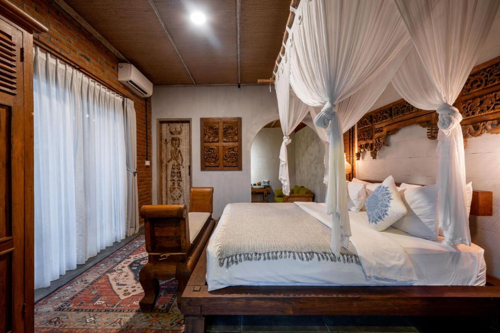 a bedroom with a bed with a canopy at Joglo Retreat in Canggu