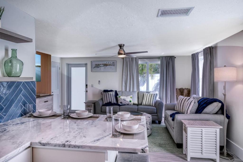 a kitchen and living room with a marble counter top at Tranquility Meets Style-Walk to beach-prvt pool. in Holmes Beach
