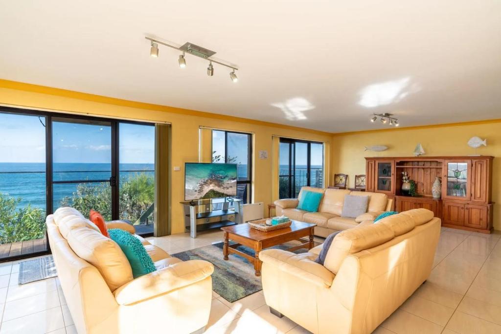 ManyanaにあるHasta Manyana ocean front villaのソファ付きのリビングルームが備わり、海の景色を望めます。