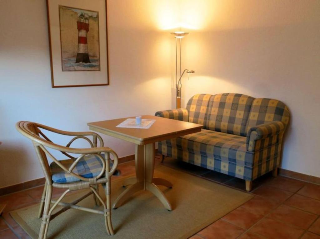 a living room with a couch and a table and a chair at Kaiserhof 010 in Wangerooge