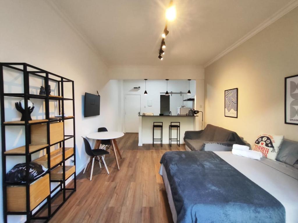 a bedroom with a bed and a living room at Studio SDU Aeroporto VLT Metrô Cinelândia in Rio de Janeiro