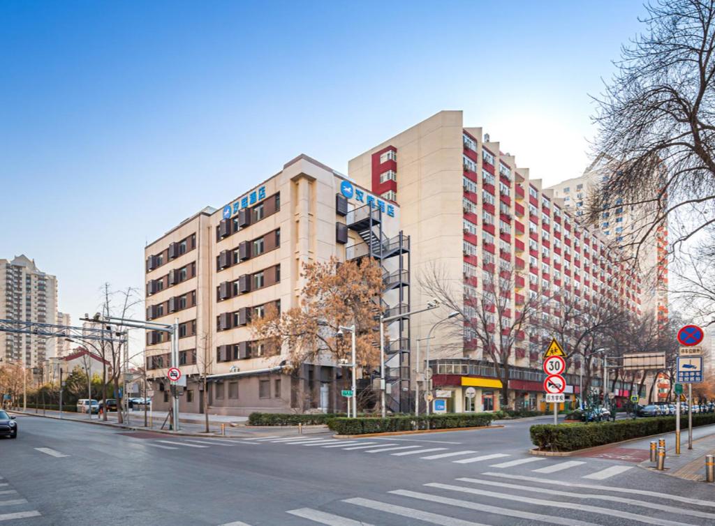 an empty city street with a large building at Hanting Hotel Beijing Fangzhuang Fangxingyuan in Beijing
