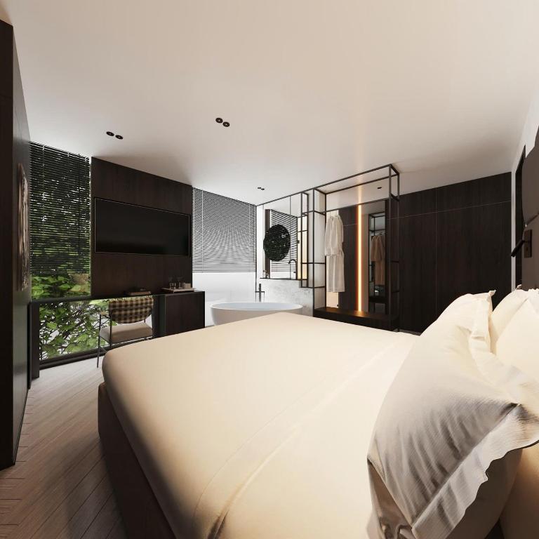 a bedroom with a large white bed and a bathroom at PureJoy Hotel Saigon in Ho Chi Minh City