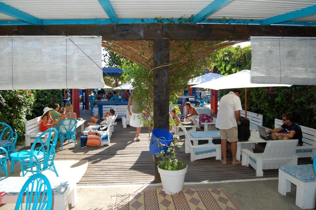 a group of people sitting on tables and chairs under an umbrella at Bungalows Tangana in Tarifa