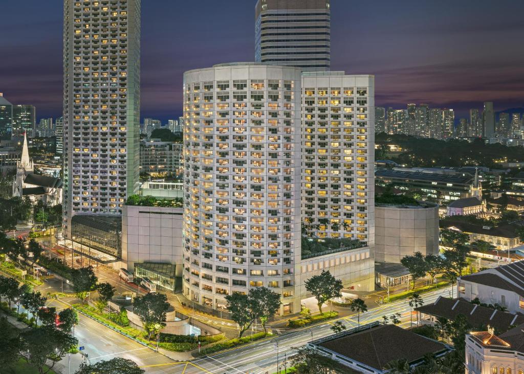 a city skyline with tall buildings at night at Fairmont Singapore in Singapore