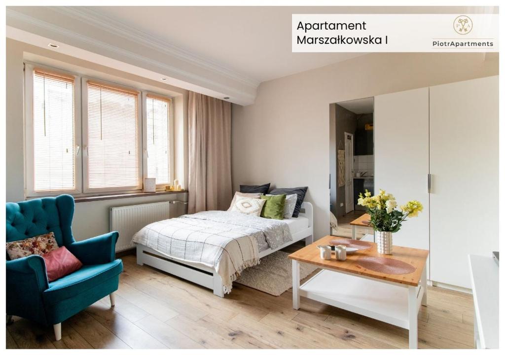a bedroom with a bed and a blue chair at PiotrApartments - Big City Life Apartments in Central Warszawa in Warsaw