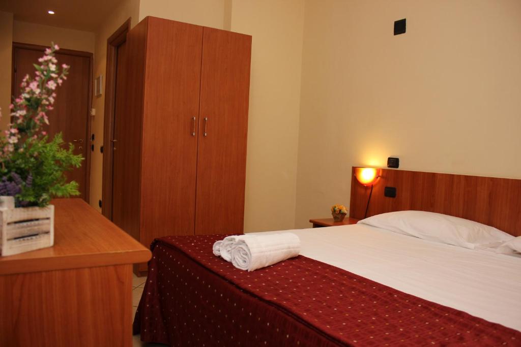 ein Schlafzimmer mit einem Bett, einer Kommode und einem Bett sidx sidx sidx sidx sidx in der Unterkunft Albergo Hotel Giardino in Desio