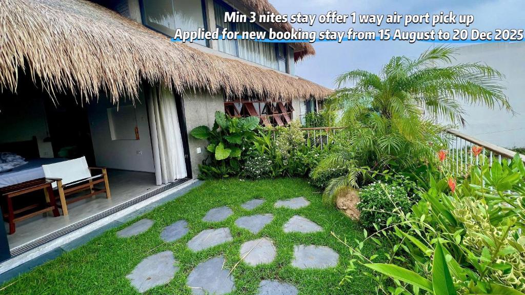 una casa con un patio de césped al lado de un edificio en Nongnia Beach Villa, en Tân Thành (1)