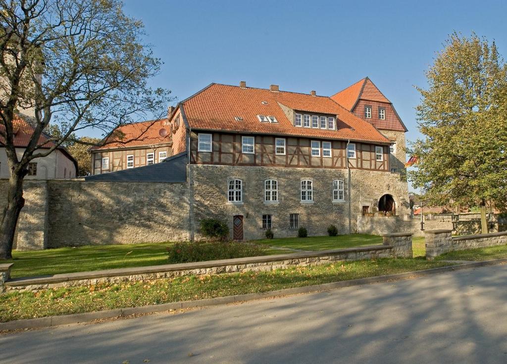 a large stone house with a red roof at Burg Warberg in Warberg