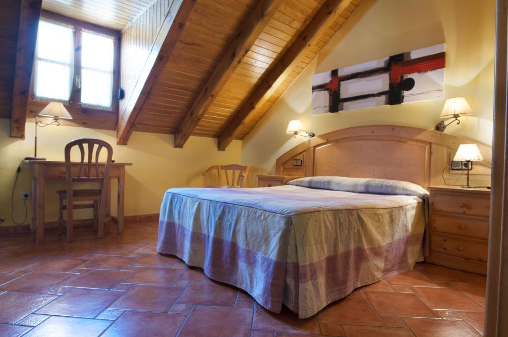 a bedroom with a large bed and a table at Hotel Pey in Bohí