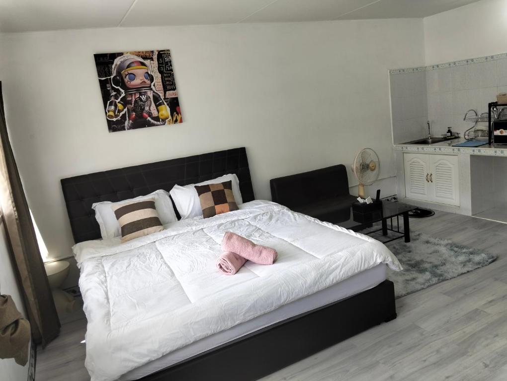 a bedroom with a bed with two pink slippers on it at อิมแพค popular condo c5 แม่ตังค์ in Ban Bang Phang