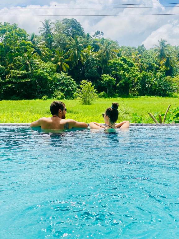 a man and a woman in the water at southern grace apartment in Unawatuna