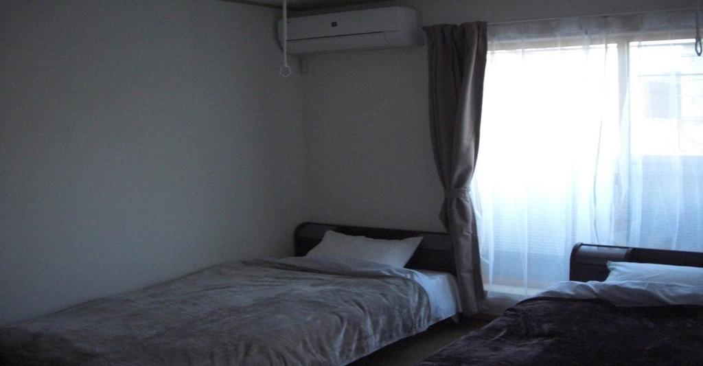 a bedroom with two beds and a window at 2-10-15 Imagawa - Apartment / Vacation STAY 7905 in Tokyo