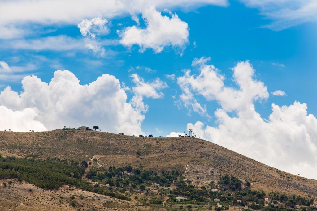 a hill with a blue sky and clouds at Licata Posti Letto in Trapani