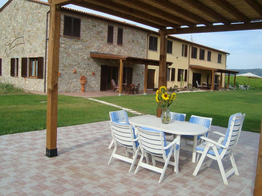 einen weißen Tisch und Stühle mit einer Blumenvase in der Unterkunft La Sosta di Braccio in Macchie