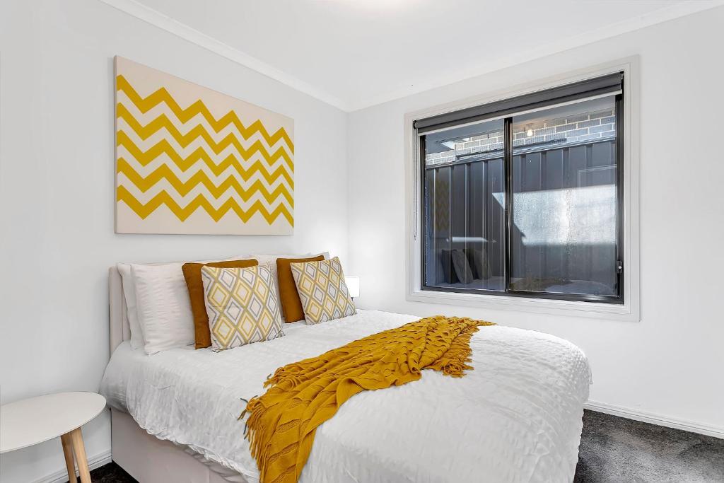 een witte slaapkamer met een bed en een raam bij East Haven Creek 