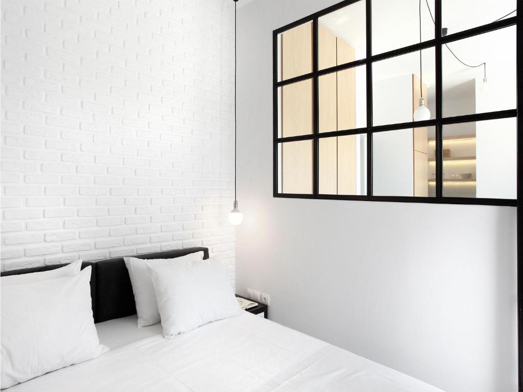 a bedroom with white walls and a bed with white pillows at Athens View Loft - 03 in Athens