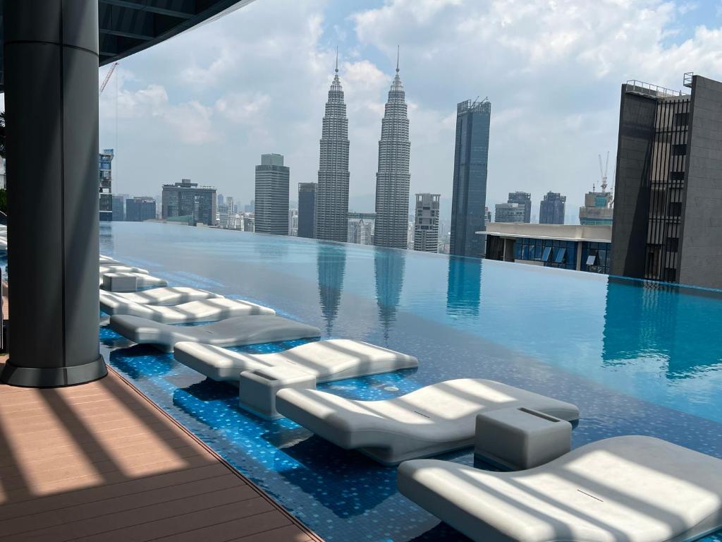 una piscina con sedie a sdraio sul tetto di un edificio di Eaton Premier Suite KLCC a Kuala Lumpur