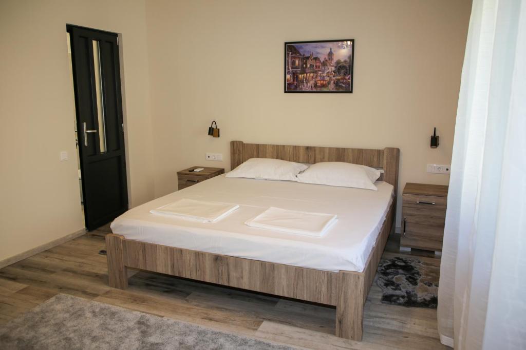 une chambre avec un grand lit avec des draps blancs dans l'établissement AKZ Apartman, à Makó