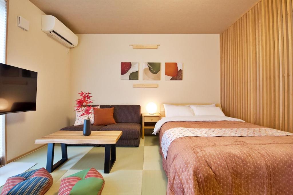 una habitación de hotel con dos camas y un sofá en Kamon Inn Uji 2-C, en Uji