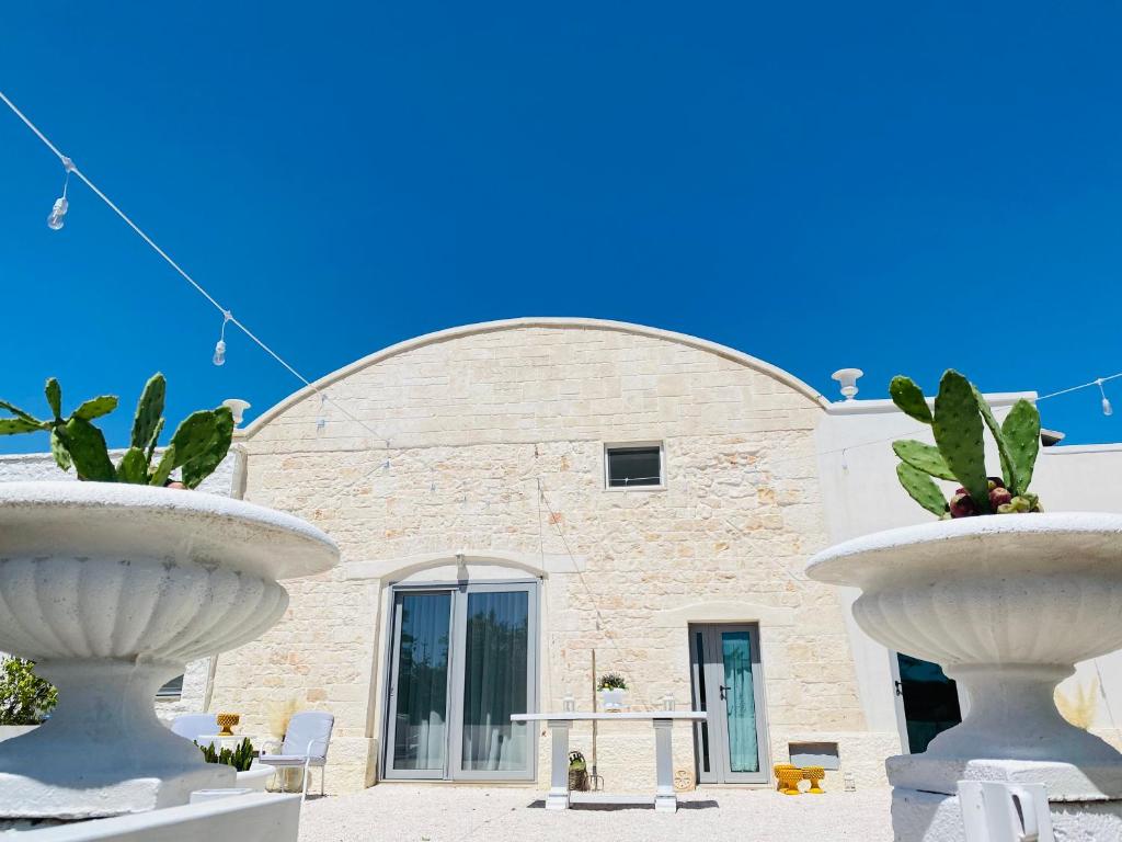Dos grandes fuentes blancas frente a un edificio en Casale Del Musico, en Locorotondo