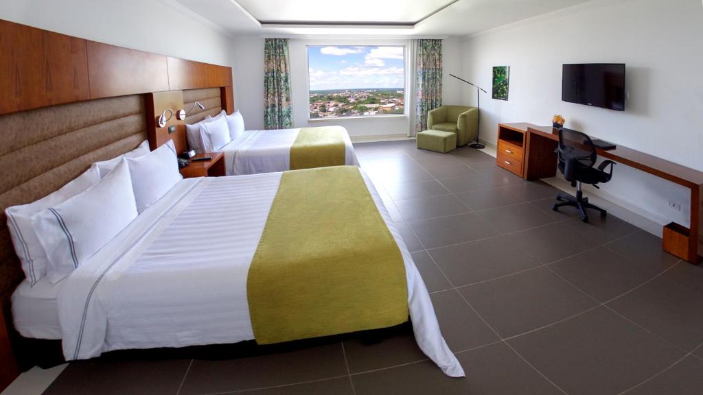 Postel nebo postele na pokoji v ubytování GHL Hotel Grand Villavicencio