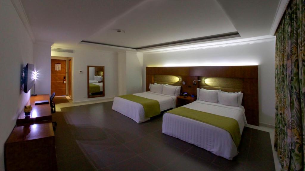 Postel nebo postele na pokoji v ubytování GHL Hotel Grand Villavicencio