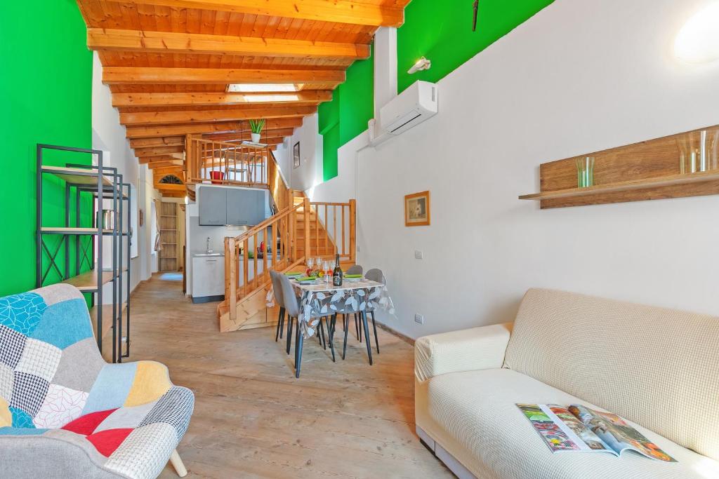 una sala de estar con una mesa y un sofá en Nido dell'Usignolo - Happy Rentals, en Riva del Garda